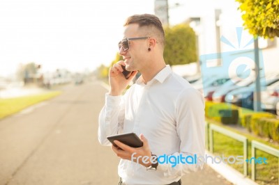 Businessman With Mobile Phone Tablet In Hands Stock Photo