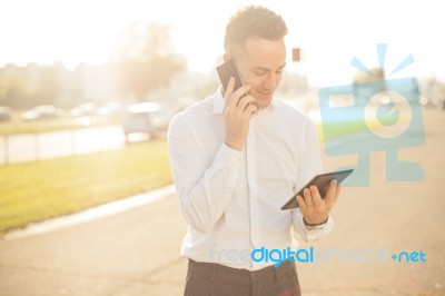 Businessman With Mobile Phone Tablet In Hands Stock Photo