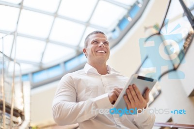 Businessman With Tablet Computer In Modern Building Stock Photo