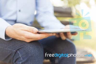 Businessman With Tablet Computer In Park Stock Photo