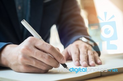 Businessman Writing In A Document. Focus On The Tip Of The Pen Stock Photo