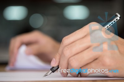 Businessman Writing In A Document. Focus On The Tip Of The Pen Stock Photo