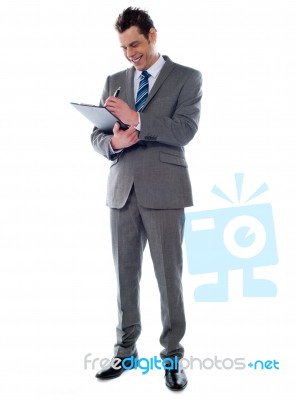 Businessman Writing On Clipboard Stock Photo