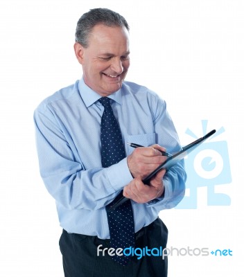 Businessman Writing On Clipboard Stock Photo