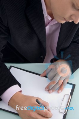 Businessman Writing On Clipboard Stock Photo