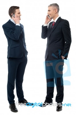 Businessmen Communicating Via Cell Phone Stock Photo