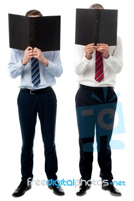 Businessmen Hiding Their Faces With Files Stock Photo