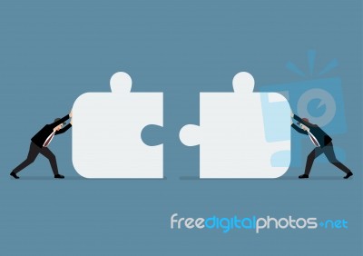 Businessmen Pushing Two Jigsaw Pieces Together Stock Image