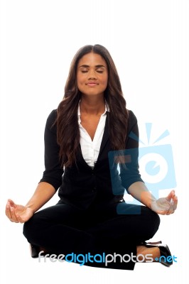 Businesswoman Meditating In Lotus Posture Stock Photo