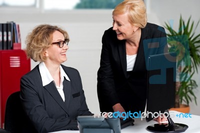 Businesswomen Enjoying At Work Desk Stock Photo