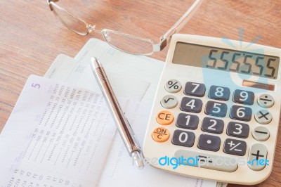 Calculator, Pen And Eyeglasses On Bank Account Passbook Stock Photo