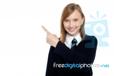 Calm And Relaxed Teen Girl Pointing Sideways Stock Photo