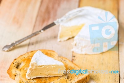 Camembert Cheese With Cut Wedge On Toasted Bread Slice And Vinta… Stock Photo