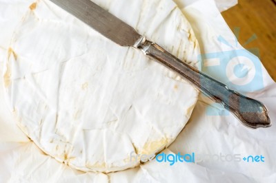 Camembert Cheese Wrapped In Paper With Vintage Knife On Wooden T… Stock Photo