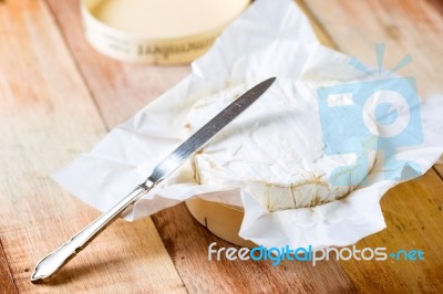 Camembert Cheese Wrapped In Paper With Vintage Knife On Wooden T… Stock Photo