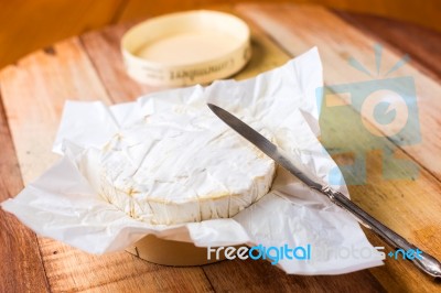 Camembert Cheese Wrapped In Paper With Vintage Knife On Wooden T… Stock Photo