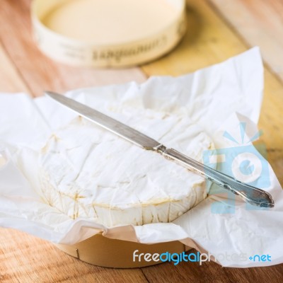 Camembert Cheese Wrapped In Paper With Vintage Knife On Wooden T… Stock Photo