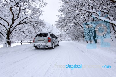 Car And Falling Snow In Winter On Forest Road With Much Snow Stock Photo