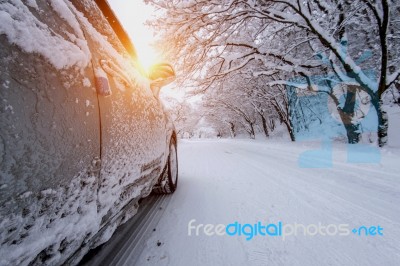 Car And Falling Snow In Winter On Forest Road With Much Snow Stock Photo