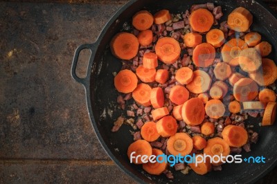 Carrots And Bacon In The Pan On The Metal Background Stock Photo