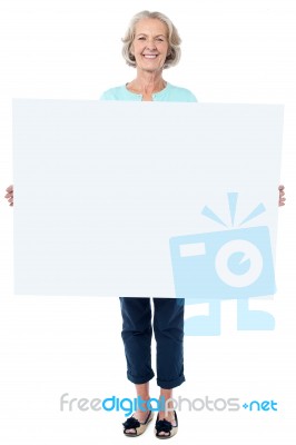 Casual Old Lady Holding A Blank Billboard Stock Photo