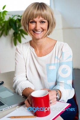 Casual Woman In Office Enjoying Her Coffee Break Stock Photo