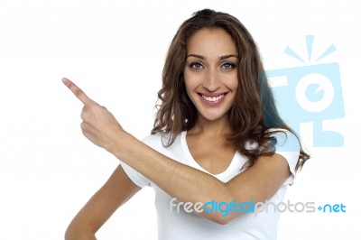 Casual Woman Pointing Towards The Copy Space Stock Photo