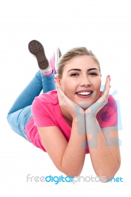 Casual Young Caucasian Girl Lying On Studio Floor Stock Photo