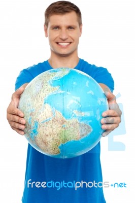 Casual Young Guy Presenting Globe Stock Photo