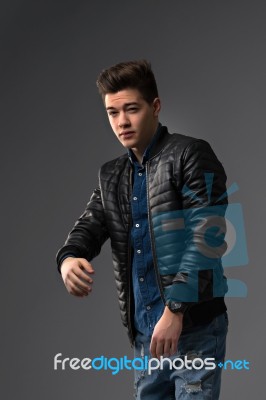 Casual Young Man In Black Leather Jacket And Denim Jeans Stock Photo