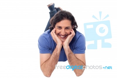 Casual Young Man Lying On The Studio Floor Stock Photo