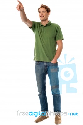 Casual Young Man Pointing At Something Stock Photo