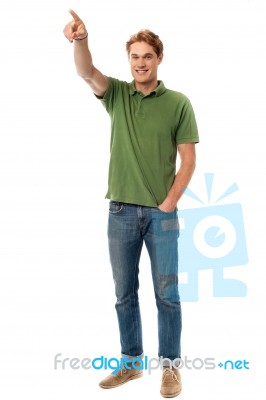 Casual Young Man Pointing At Something Stock Photo