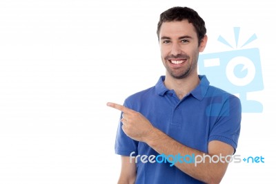 Casual Young Man Pointing Away Stock Photo