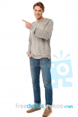 Casual Young Man Pointing Away Stock Photo