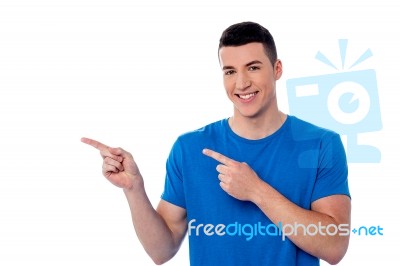 Casual Young Man Pointing Away Stock Photo