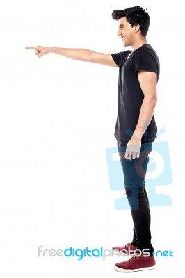 Casual Young Man Pointing To His Side Stock Photo