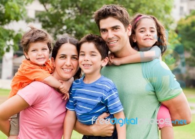 Caucasian Parents Piggyback Their Children Stock Photo