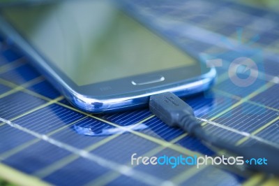 Charging Mobile Phone With Solar Charger Stock Photo