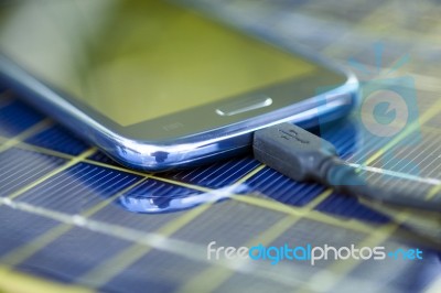 Charging Mobile Phone With Solar Charger Stock Photo