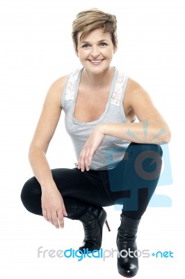 Charming Woman In Squatting Posture Stock Photo