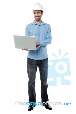 Cheeful Builder Surfing On His Laptop Stock Photo