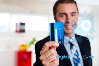 Cheerful Businessman Holding Up His Credit Card Stock Photo