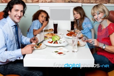 Cheerful Family Enjoying Dinner Stock Photo