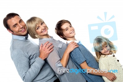 Cheerful Family Of Four Leaning Backwards Stock Photo