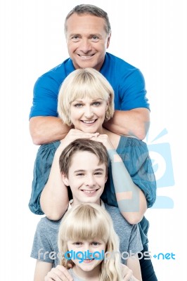 Cheerful Family Of Four Standing In A Row Stock Photo