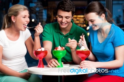 Cheerful Friends Enjoying Tempting Dessert Stock Photo