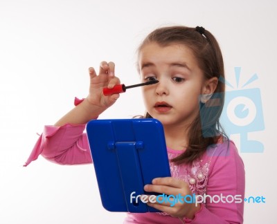 Cheerful Girl Colors Eye Makeup In The Mirror Stock Photo