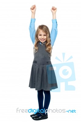 Cheerful Kid Raising Her Hands In Excitement Stock Photo