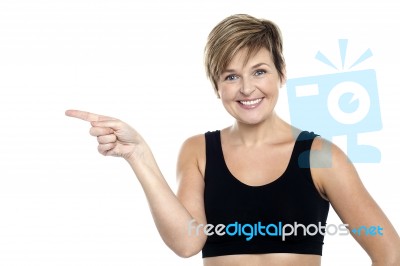 Cheerful Middle Aged Woman Pointing At Copy Space Area Stock Photo